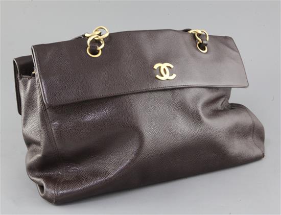 A ladies textured brown leather Chanel handbag, length 16in., with slip case